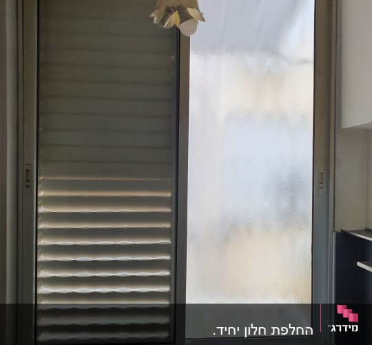 חלון זכוכית עם תריסים סגורים ומנורה תלויה
